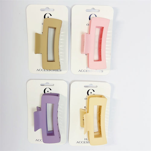 Large rectangular hair claw clips with cut-out centre; Matte plastic finish; Soft pastel colours including beige, pink, purple and yellow; Mounted on white branded hair accessories cards;