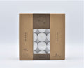 brown cardboard box packaging; clear plastic window showing white tealights; white wax candles; each tealight in silver metal cup; text on box states 4 hour burn time;
