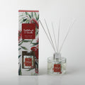 clear round glass bottle with silver collar; white reed sticks; decorative box with bottlebrush flower and red parrot artwork; red label with white text on bottle and box;