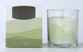 clear glass container; white candle wax; green label with gold text; two-tone green cardboard box packaging; 120g indicated on label and box;