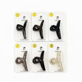 Long twist cross style hair claw clip; Mounted on white branded backing card; Clips shown in dark, tortoiseshell and clear tones; Curved teeth along the inner edge of the clip;