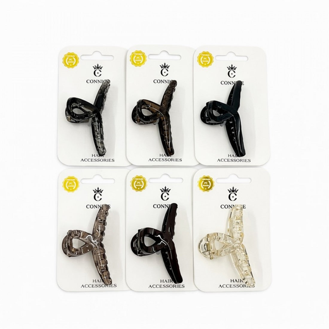 Long twist cross style hair claw clip; Mounted on white branded backing card; Clips shown in dark, tortoiseshell and clear tones; Curved teeth along the inner edge of the clip;