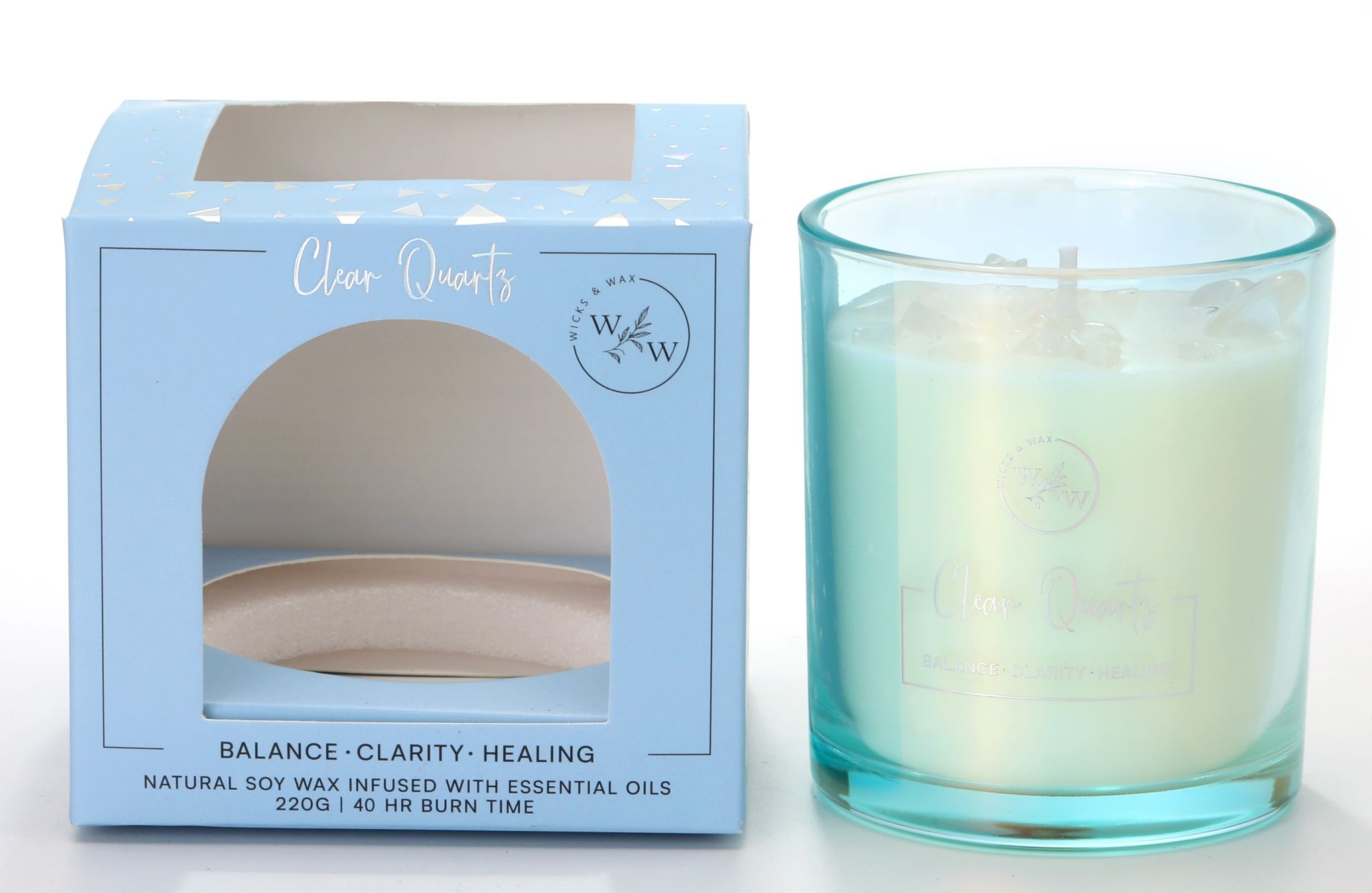 Light blue box with 'Clear Quartz' text; Clear glass candle holder with light blue tint; White candle wax with clear quartz crystals embedded on top; Label mentions 'Balance Clarity Healing' and 40 hour burn time;