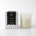 Frosted white glass container with lid; Gold lettering on glass; Black and white striped packaging with gold accents; Simple, elegant design;