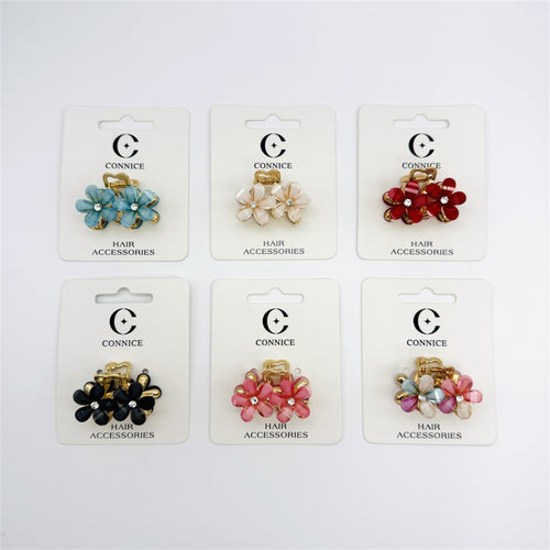 Small flower-shaped hair claw clip; Gold-tone alloy claw base; Petal-style flowers with central rhinestone detail; Mounted on branded backing card labelled "Connice" and "Hair Accessories"; Shown in several assorted colours including blue, cream, red, black, pink and multicolour;