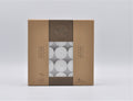 brown cardboard packaging; transparent window showing white tealight candles; pack of 50 tealights; text indicating 4 hours burning time; lead free and smokeless icons on packaging;
