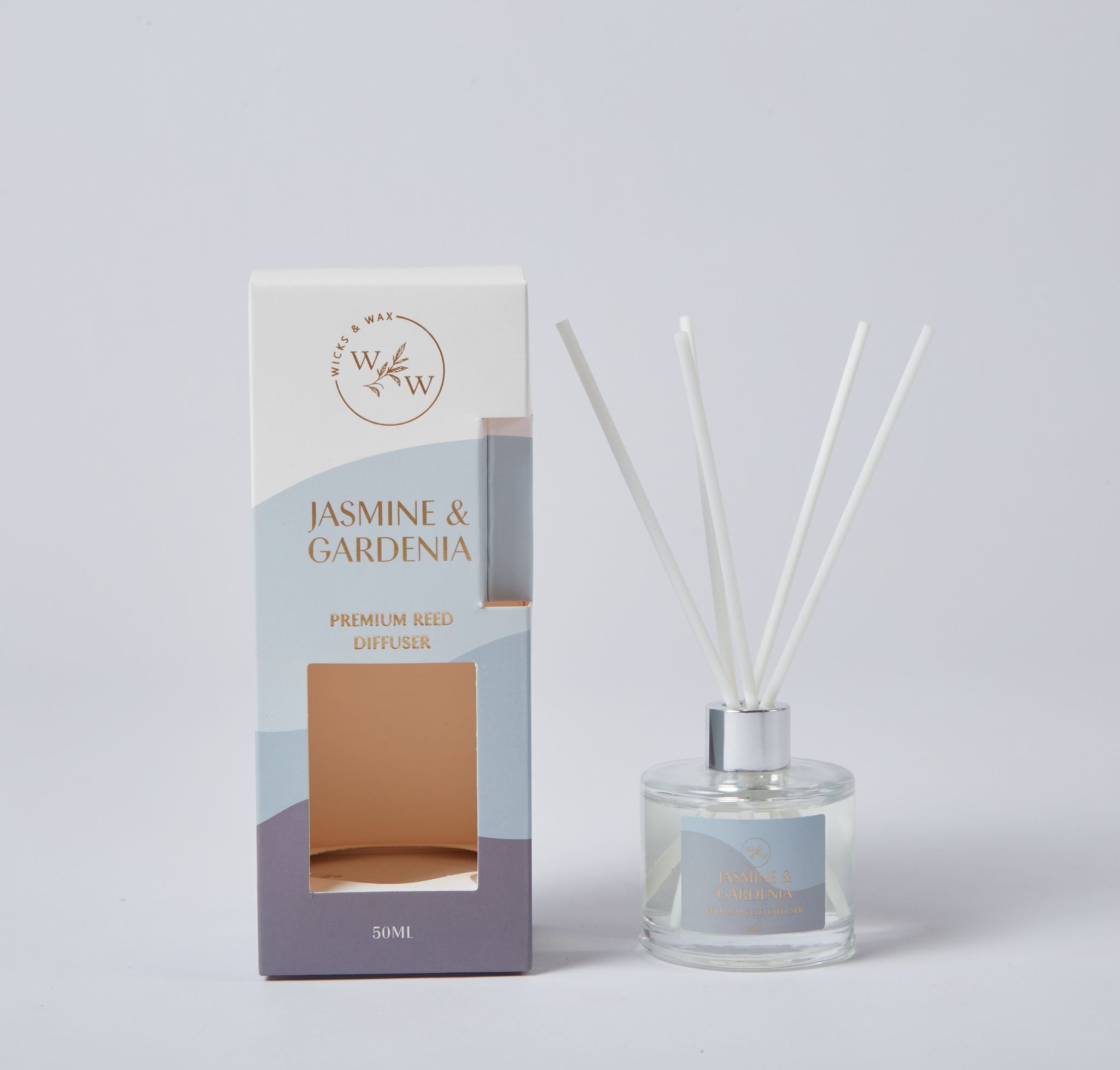 Clear round glass bottle with silver neck; White reed sticks included; Box with pale blue, white and purple colour blocks; Gold text on both box and bottle label;