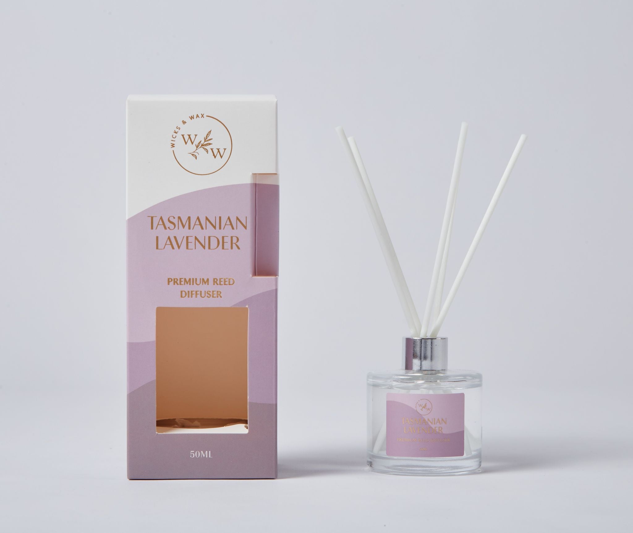 Clear glass bottle with silver metal collar; White reed sticks inside diffuser; Rectangular box with lavender and white colour gradient; Box labelled 'Tasmanian Lavender' and 'Premium Reed Diffuser'; 50ml volume indicated on box and bottle;