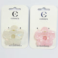 Flower-shaped claw clip design; One clip in pearlescent white, one in light pink; Glossy acrylic finish with marbled effect; Gold-tone metal spring mechanism; Mounted on white CONNICE branded backing cards;