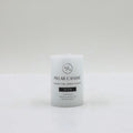 white cylindrical pillar candle; flat top surface; black text printed on candle; label states 5x7cm size; smooth wax finish;
