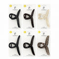 Hair claw clip with twist cross shape; Approx. 6cm length; Made from glossy plastic material; Shown in assorted neutral and tortoiseshell-style colours; Packaged on white backing card branded “Connice”;