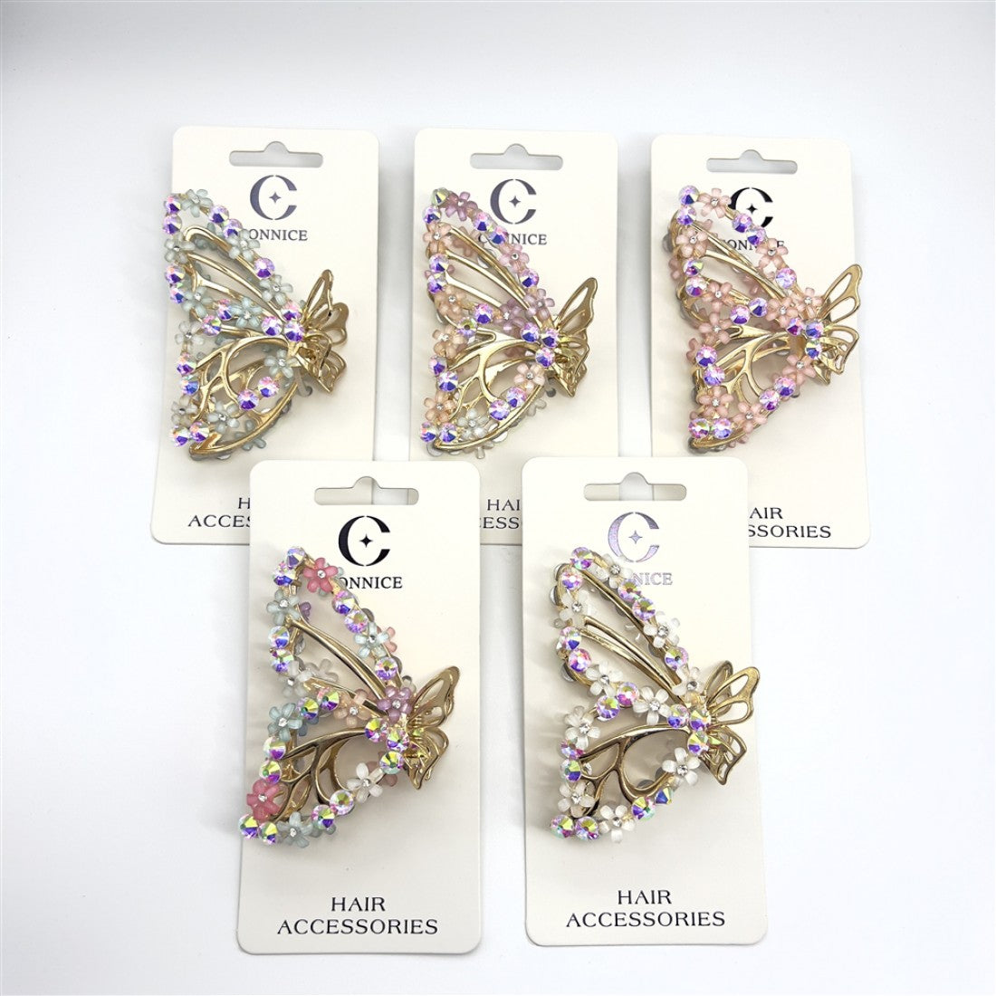 Gold-tone butterfly-shaped claw clip; Decorated with small flower beads and rhinestones; Iridescent and pastel pink accents; Mounted on white branded backing card; Approximate length around 7.5cm;