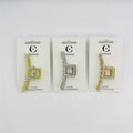 Rectangular claw clip with open geometric shape; Covered in clear rhinestones along the frame; Metallic alloy finish in light and gold tones shown; Packaged on white backing card labelled hair accessories;