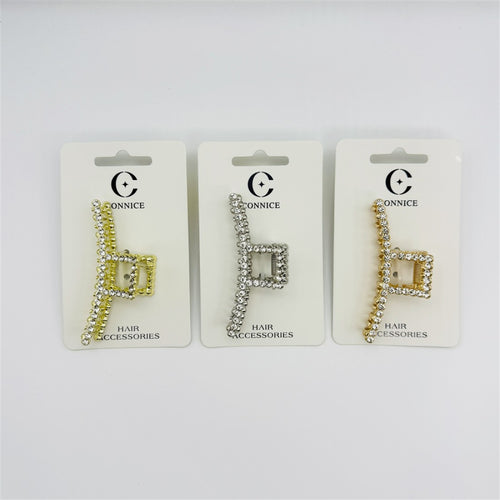 Rectangular claw clip with open geometric shape; Covered in clear rhinestones along the frame; Metallic alloy finish in light and gold tones shown; Packaged on white backing card labelled hair accessories;