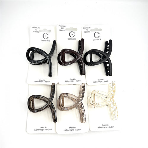 Cross-shaped claw clip design; Approx. 8cm medium size; Made from glossy plastic/PC material; Packaging shows assorted neutral colours including black, brown and clear; Mounted on white backing card with simple branding;