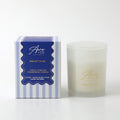 Frosted glass jar with glass lid; White candle wax; Blue and white striped gift box; Gold scripted brand and product name on jar;