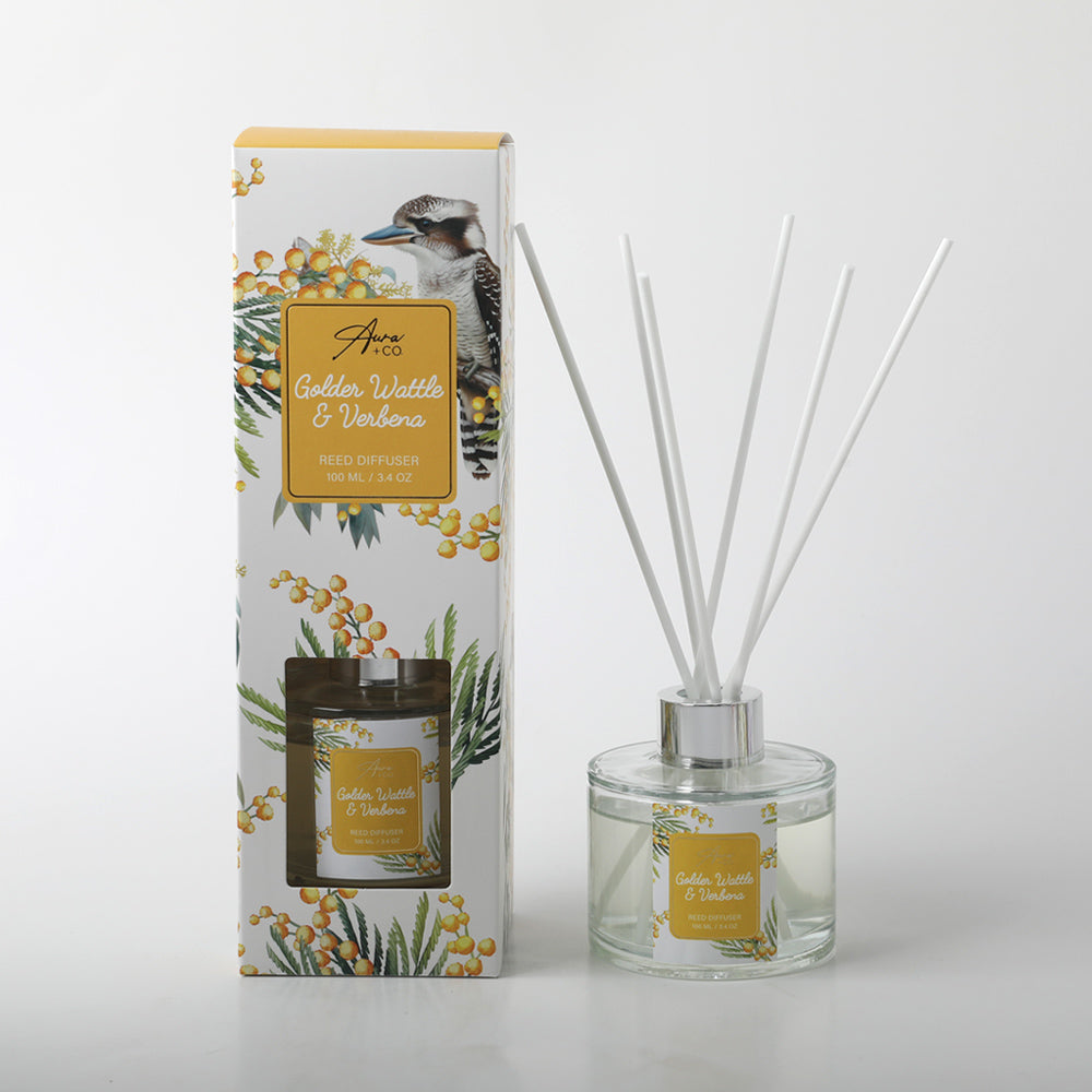 Clear glass diffuser bottle with silver collar; Label and packaging feature golden wattle plant design; White reed sticks included; Decorative box with native bird and floral artwork;