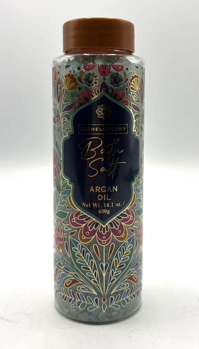 Clear plastic cylindrical container; Brown twist-off lid; Decorative floral pattern in multiple colours; Blue label with gold text; Contains coarse bath salts inside;