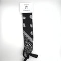 Black fabric bandana; White paisley and geometric print; Long rectangular shape; Knotted end detail; Hanging on branded CONNICE card packaging;