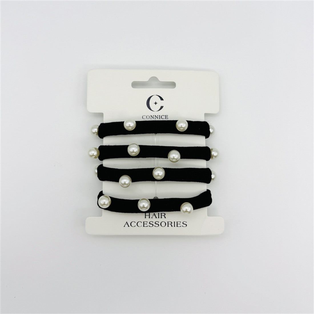 Four black elastic hair ties on retail card; Each tie decorated with round pearl-look beads; White backing card with brand name and logo; Simple, minimal packaging design;