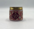 gold metal screw lid; decorative floral patterned label; pink tinted cream visible inside jar; round clear plastic jar;