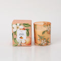 Orange blossom floral pattern on glass holder; Matching orange and green botanical design on box; Soft orange tinted glass candle holder; Boxed candle packaging; 180g weight indicated;
