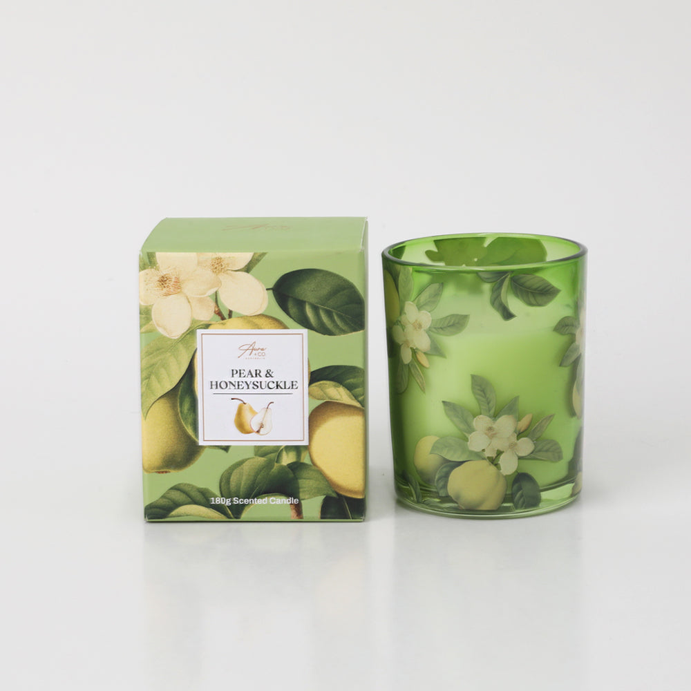 Green glass candle holder with pear and honeysuckle floral print; Matching green box with pear and flower illustrations; 180g candle weight indicated on packaging; White candle wax visible inside glass;