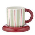 Ceramic cup with vertical mint green and white stripes; Russet red handle and matching saucer; Compact size, approximately 13cm cup height and 10cm saucer diameter; Glossy finish on cup and saucer;