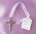 silver-tone metal cross with clear stones; heart shape in centre; white fabric hanging ribbon; attached white gift tag with ribbon bow;