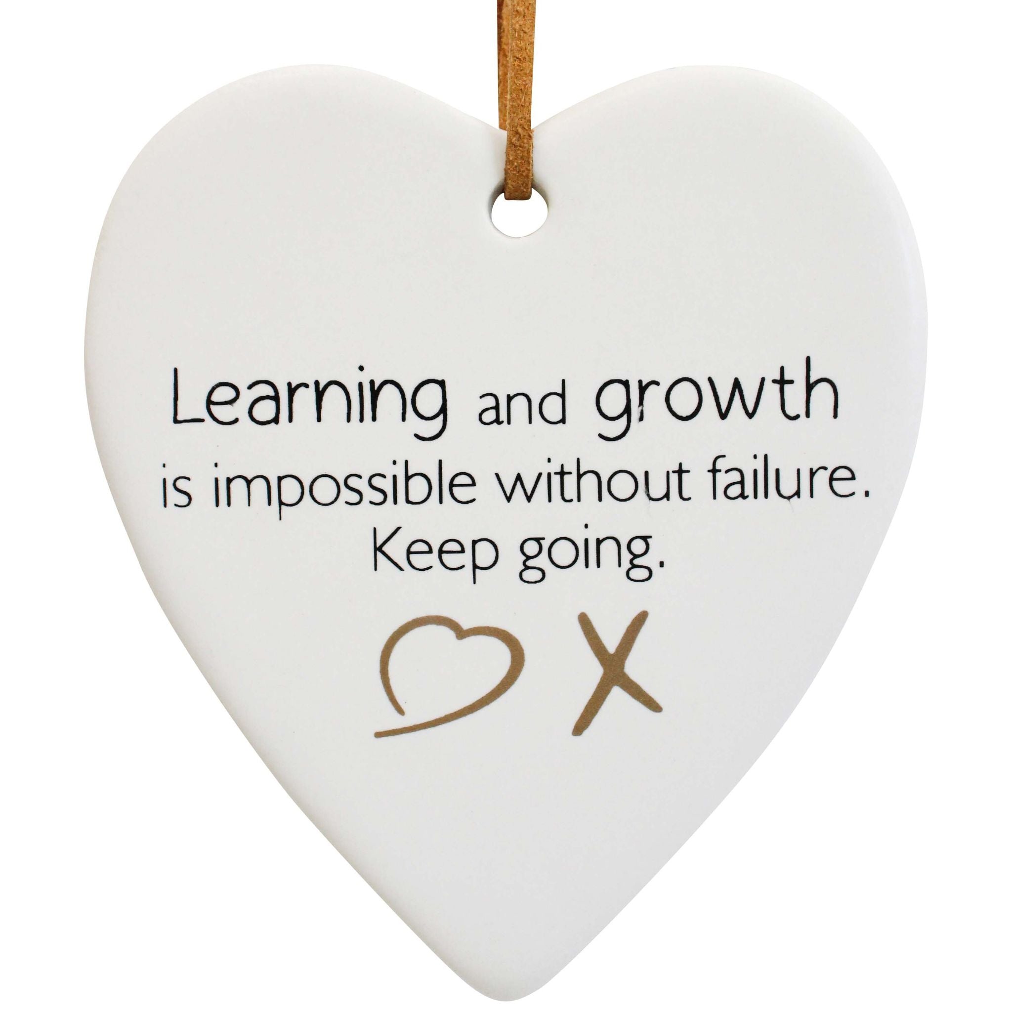 white ceramic heart shape; black and brown printed text; faux-leather hanging cord; matte finish ceramic; minimalist font;