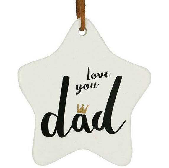 white ceramic star shape; black script text reading 'love you dad'; small gold crown detail on letter 'a'; brown leather-style hanging strap;