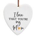 heart-shaped ceramic piece; cream colour with shiny golden heart detail; black cursive and block lettering; brown leather hanging strap;