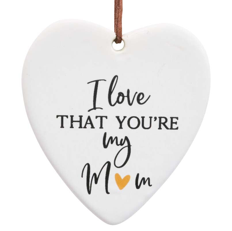 heart-shaped ceramic piece; cream colour with shiny golden heart detail; black cursive and block lettering; brown leather hanging strap;