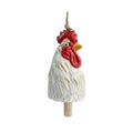 White ceramic rooster head and upper body; Red comb and wattle with yellow beak; Hanging from a natural twine cord; Glossy glazed finish with textured feather detail; Small cylindrical piece at base for chime function;