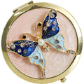 gold round compact case; blue and pink butterfly decoration; faux pearl detail; rhinestones embellishment; textured gold finish;