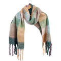 soft muted earthy colours green, beige, peach and purple; long rectangular shape with twisted tassels at ends; fabric appears soft and slightly fuzzy; scarf is displayed hanging on wooden hanger;