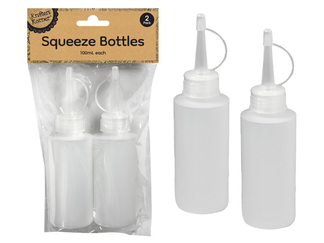 Two translucent squeezable plastic bottles; Each bottle has a pointed nozzle tip; Attached small white flip caps on each nozzle; Bottles held in clear plastic packaging with brown label;