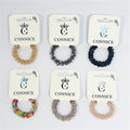 Coiled spiral hair tie design; Clear and coloured faceted beads creating a crystal look; Multiple colour options shown including gold, dark blue, multicolour and neutrals; Each hair tie displayed on white CONNICE branded card backing;