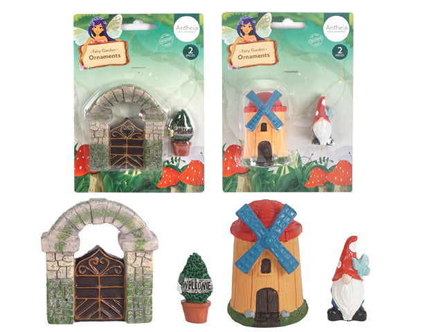 Two sets of ornaments shown, each containing two pieces; One set features a stone archway with a metal gate and a potted shrub; Other set includes a small windmill with blue blades and a red-roofed gnome figurine; Ornaments are colourful, detailed, and appear made of painted resin;