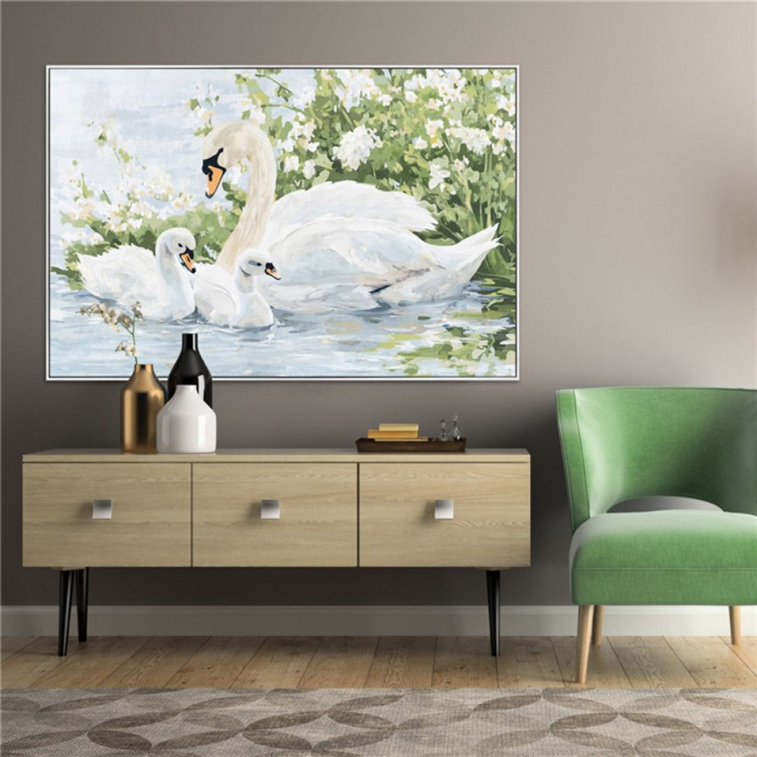 White swans in water with greenery background; Framed with thin silver or light grey frame; Painting appears textured oil style; Rectangular shape; Soft natural colour palette;