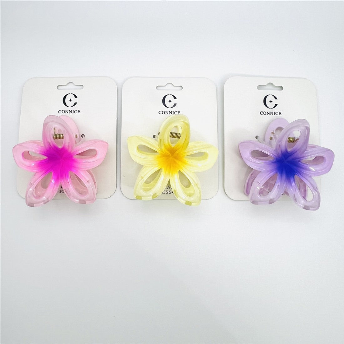 Flower-shaped claw clips with hollow petal design; Pastel colours including pink, yellow and purple; Soft gradient colour at the centre of each flower; Plastic body with visible metal spring mechanism; Mounted on white branded backing cards;