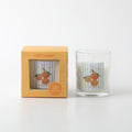 Candle in clear glass container; Orange fruit illustration label; Orange coloured packaging box; White candle wax; Compact size approx 6.5 x 7.5 cm;