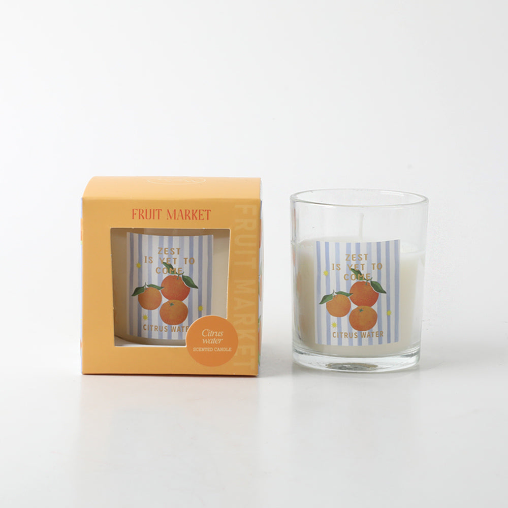 Candle in clear glass container; Orange fruit illustration label; Orange coloured packaging box; White candle wax; Compact size approx 6.5 x 7.5 cm;