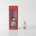 clear glass bottle with gold cap; red and white striped label with strawberry illustration; white diffuser reeds; red packaging box with window;