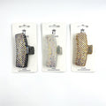 Rectangular claw clip shape; Covered in small rhinestones; Shown in metallic tones including black, silver and gold; Packaged on white backing card labelled "Hair Accessories";