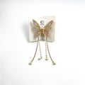 Gold-toned butterfly-shaped claw clip; Wings decorated with small clear rhinestones; Long dangling chains with faux pearls; Mounted on branded hair accessory card packaging;