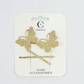 Set of two gold-tone hair clips; Large butterfly shapes covered in clear rhinestones; Straight bar clip with matching rhinestones; Mounted on branded white backing card labelled hair accessories;