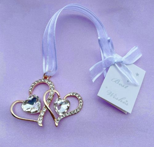 Gold-tone double hearts linked together; Clear crystal accents along the hearts; White satin ribbon for hanging; Small tag with 'Best Wishes' message;