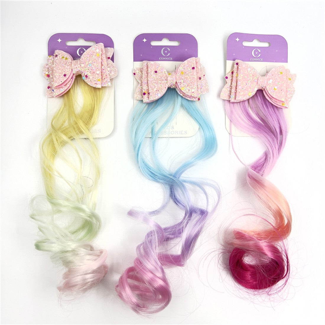 Long curly synthetic hair extension attached to clip; Pastel gradient colours including yellow, blue, purple and pink variations; Large pink glitter bow with multicoloured sparkles; Mounted on purple and cream branded backing card;