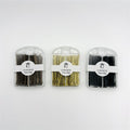 Hair pins packed in small clear plastic cases; Three colours visible: dark brown, gold and black; Front label shows brand name and non-slip text; Pins are straight bobby pin style, 6.5cm long;